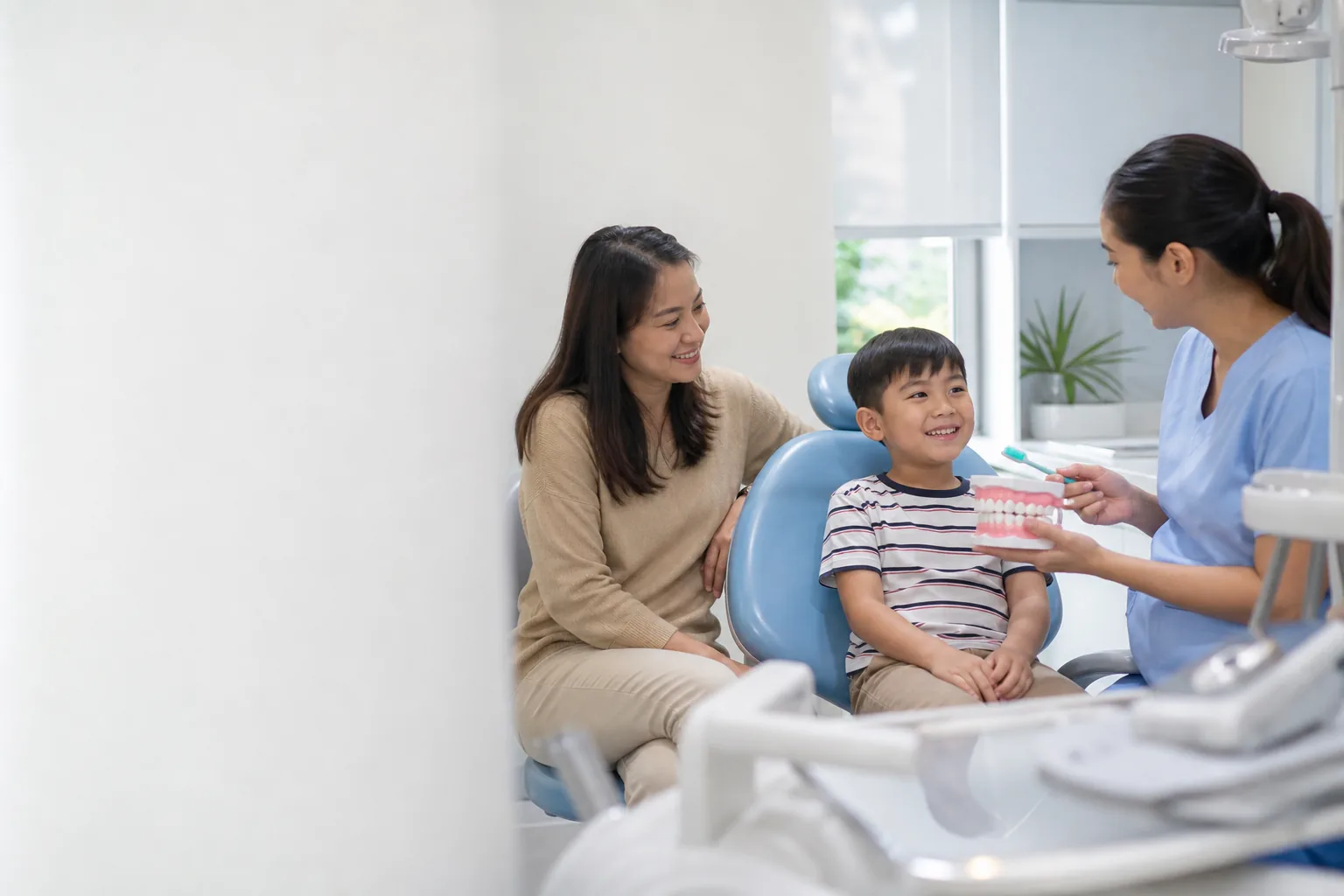 Filipino family speaking with a dental professional in a welcoming clinic